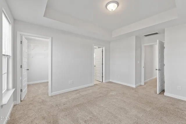 a view of an empty room with window and closet area