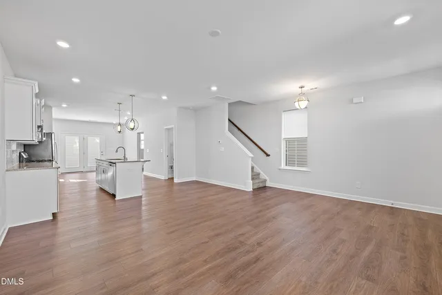 a large kitchen with granite countertop a large counter top a sink stainless steel appliances and cabinets