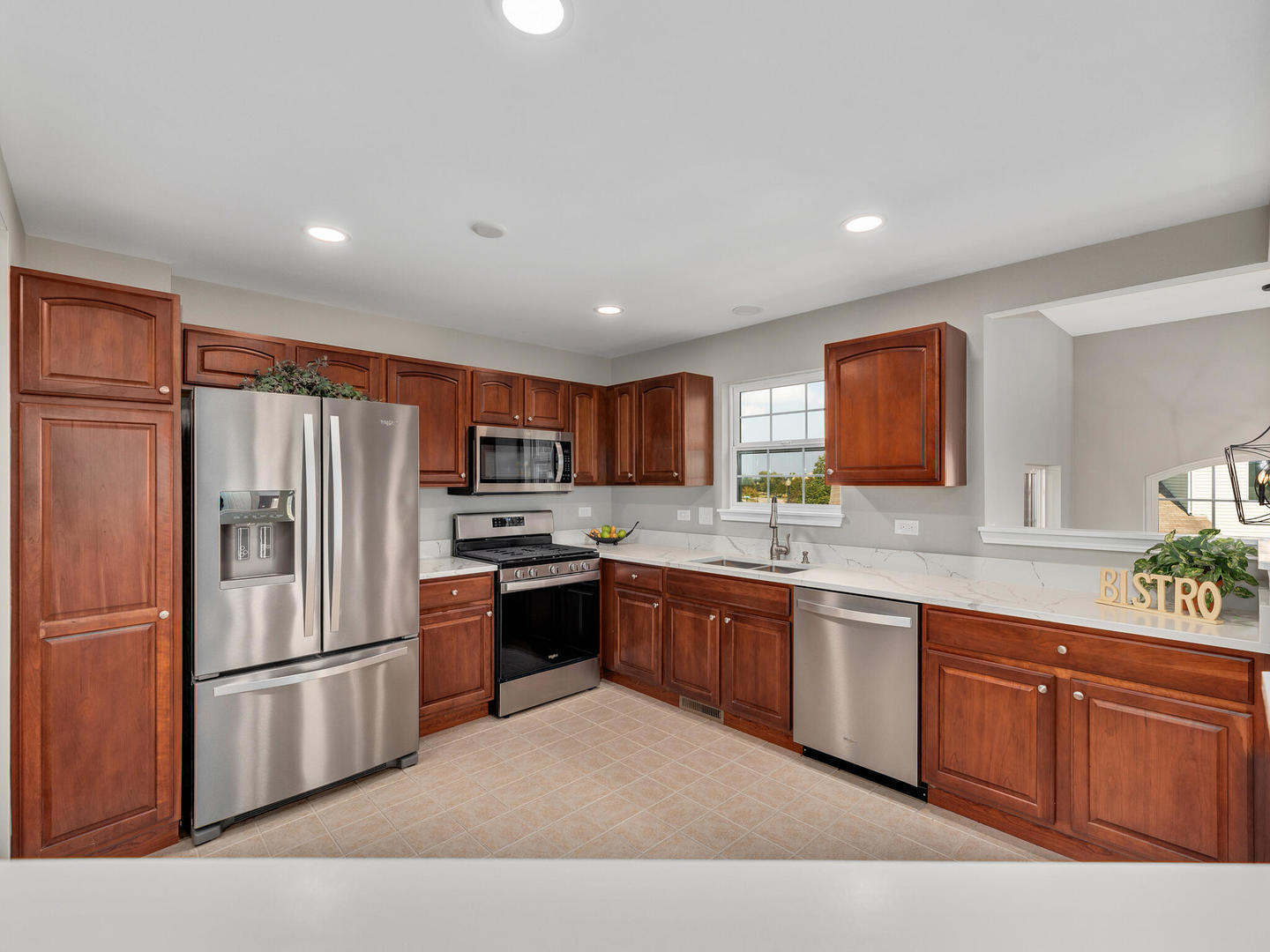 1117 Draper Road McHenry, IL 60050 - Photo 6 of 26 a large kitchen with stainless steel appliances granite countertop a refrigerator a sink dishwasher a oven with white cabinets and wooden floor