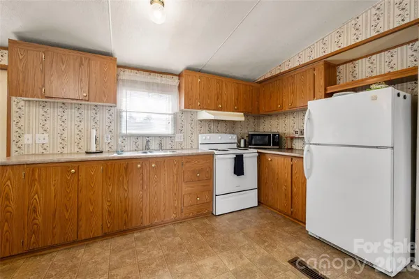 a kitchen with granite countertop white refrigerator sink and cabinets