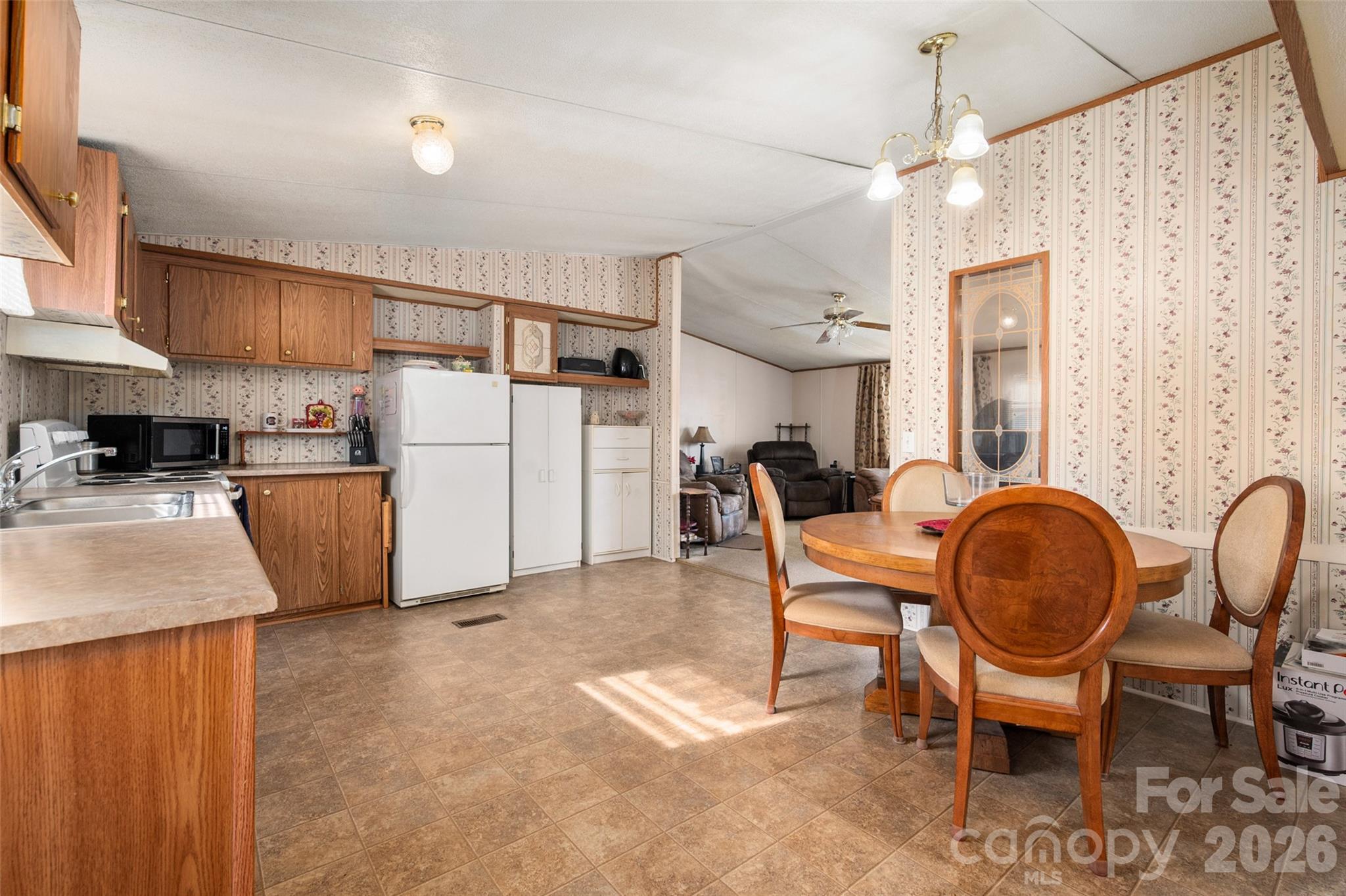 2748 Flat Creek Road Lancaster, SC 29720 - Photo 7 of 24 a kitchen with refrigerator a dining table and chairs