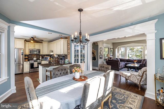 a living room with furniture a chandelier and a dining table