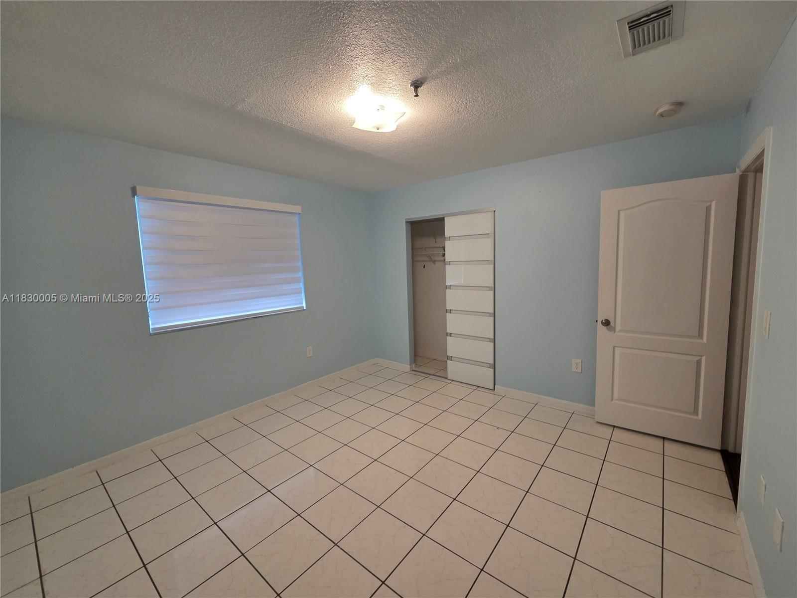 8360 Northwest 103rd Street, Unit 207E Hialeah Gardens, FL 33016 - Photo 16 of 25 a view of an empty room and window