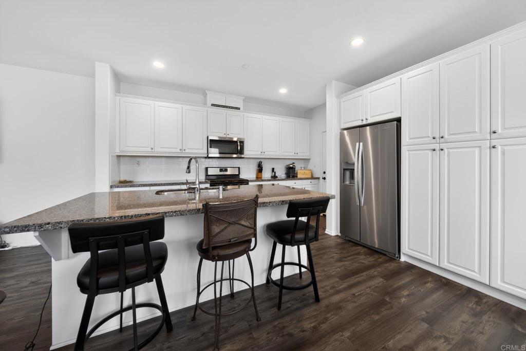 21641 Trail Ridge Drive Escondido, CA 92029 - Photo 7 of 43 a kitchen with stainless steel appliances a table chairs refrigerator and microwave