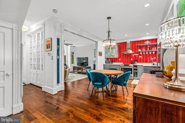 a dining room with furniture a chandelier and wooden floor