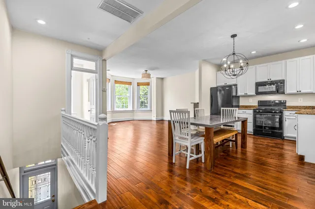 a view of a dining room with furniture a chandelier and wooden floor