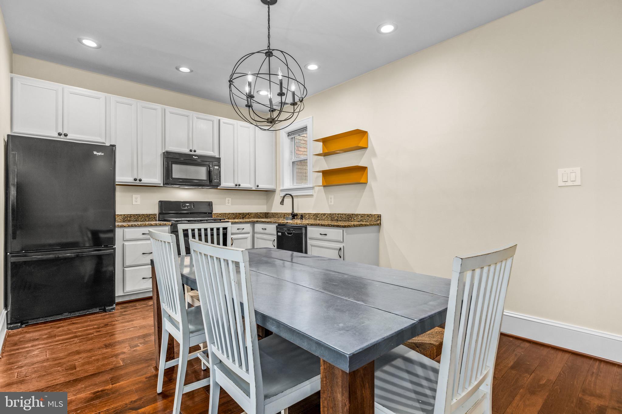 502 G Street Northeast Washington, DC 20002 - Photo 25 of 39 a kitchen with stainless steel appliances granite countertop a dining table chairs and a refrigerator
