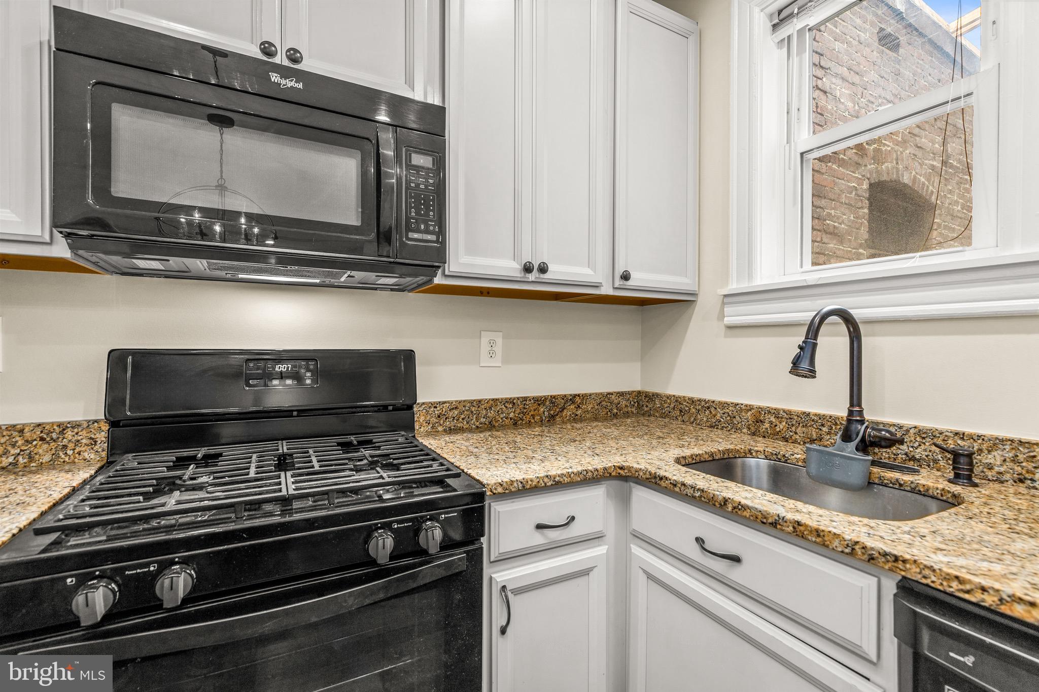 502 G Street Northeast Washington, DC 20002 - Photo 27 of 39 a kitchen with stainless steel appliances granite countertop a sink stove and microwave