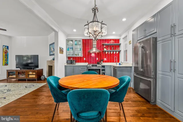 a view of a dining room with furniture a chandelier and wooden floor