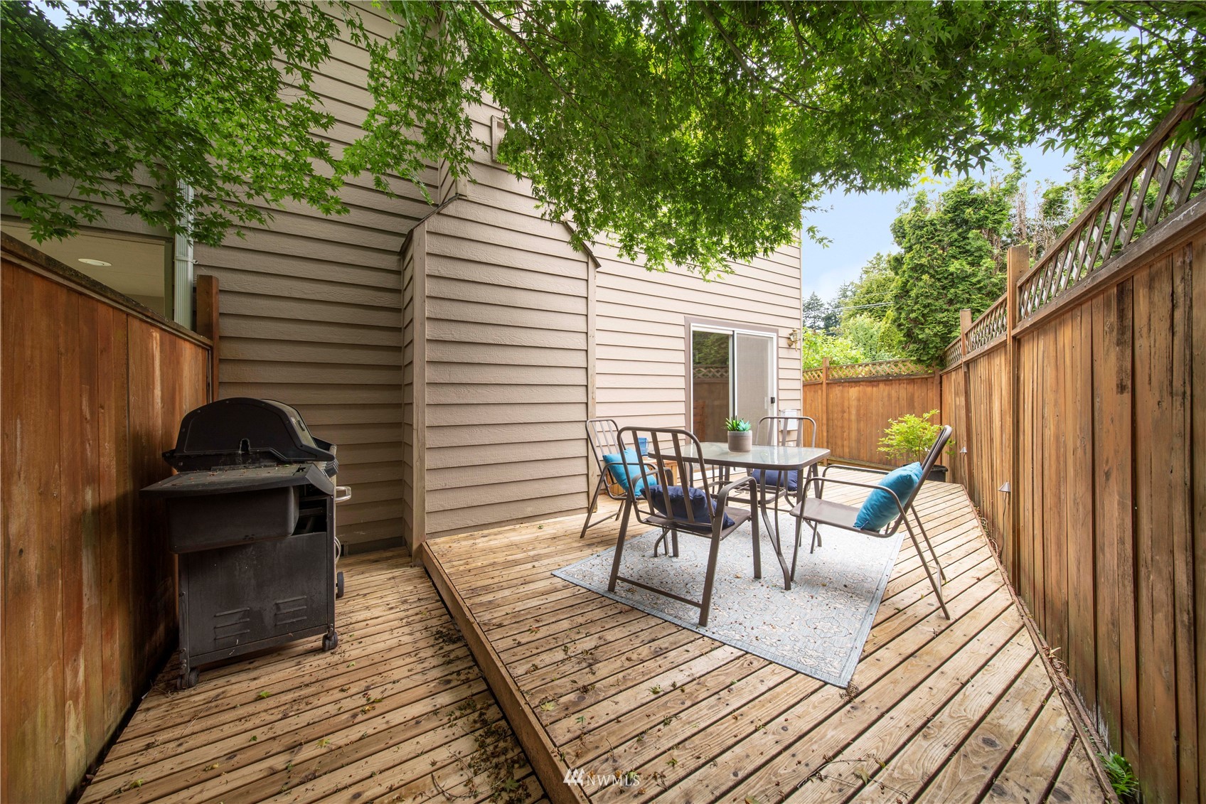 6018 Lowell Road Everett, WA 98203 - Photo 17 of 21 a view of a patio with table and chairs with wooden floor and fence