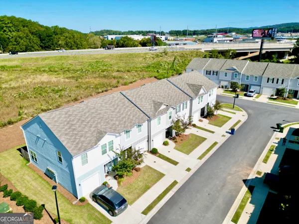 an aerial view of residential houses with outdoor space and ocean view