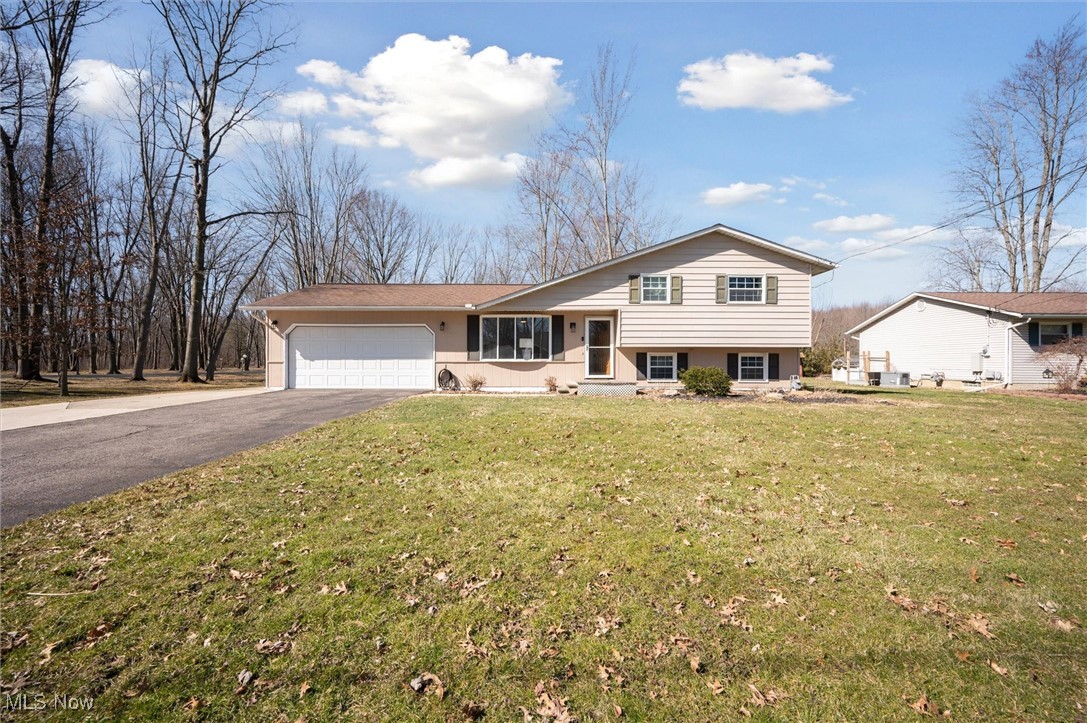 5476 Lear Nagle Road North Ridgeville, OH 44039 - Photo 4 of 38 Splint-level home with aphalt driveway, stucco siding, a garage, and a front lawn