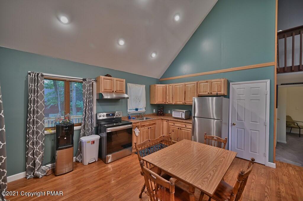 152 Canterbury Road Bushkill, PA 18324 - Photo 12 of 57 a kitchen with stainless steel appliances granite countertop a refrigerator a stove top oven a sink dishwasher and wooden cabinets with wooden floor