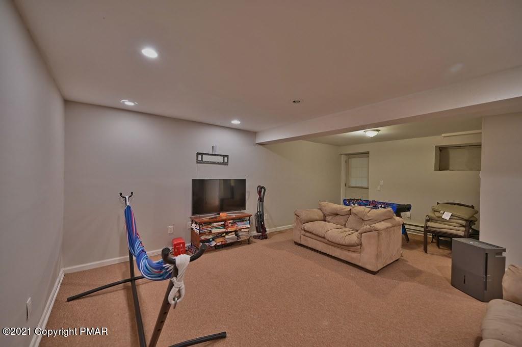 152 Canterbury Road Bushkill, PA 18324 - Photo 38 of 57 a living room with furniture a flat screen tv and a window