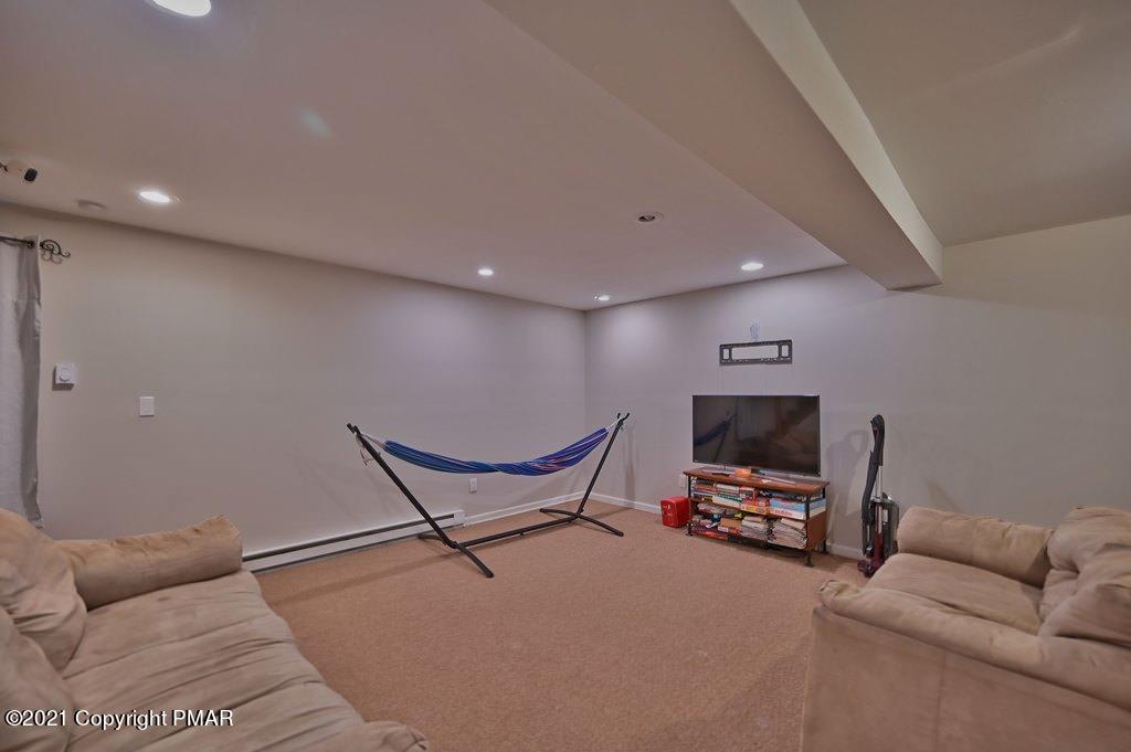 152 Canterbury Road Bushkill, PA 18324 - Photo 39 of 57 a living room with furniture a flat screen tv and a mirror