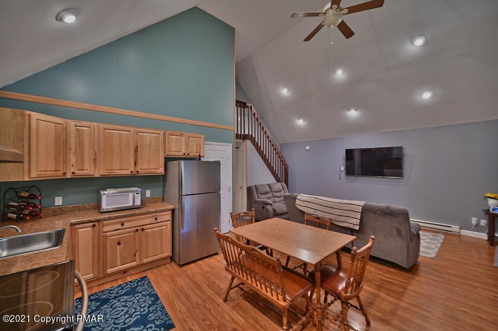 152 Canterbury Road Bushkill, PA 18324 - Photo 8 of 57 a kitchen with a refrigerator a stove a sink dishwasher with a dining table and chair with wooden floor