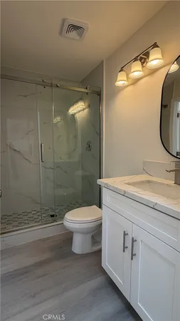 a bathroom with a granite countertop toilet sink and shower