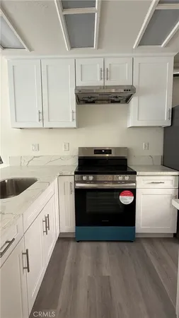 a kitchen with stainless steel appliances granite countertop a stove and a white cabinets