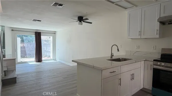 a kitchen with a sink cabinets and wooden floor