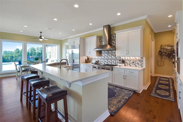 a kitchen with a table chairs stove and white cabinets