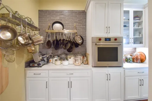 a kitchen with a sink and a stove with wooden floor