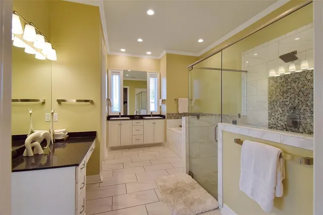 a bathroom with a double vanity sink a mirror and a bathtub