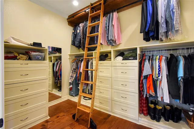 a view of walk in closet with clothes and shoes