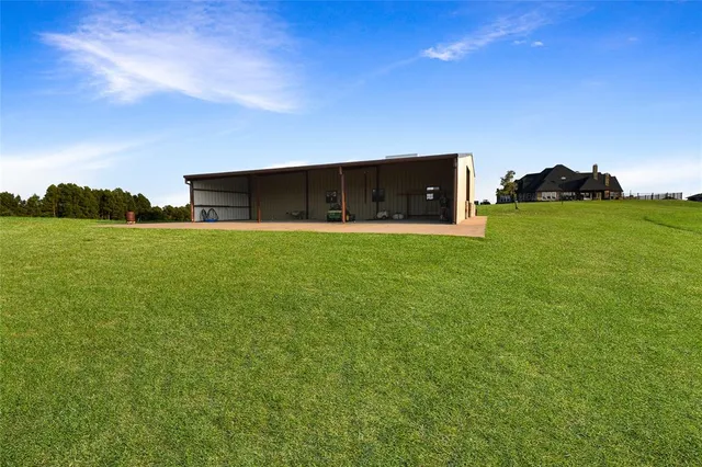 a view of a green field with an trees in the background