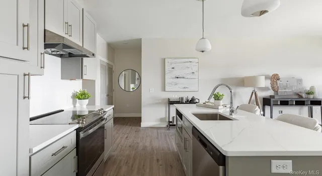a kitchen with stainless steel appliances granite countertop a sink dishwasher stove and refrigerator