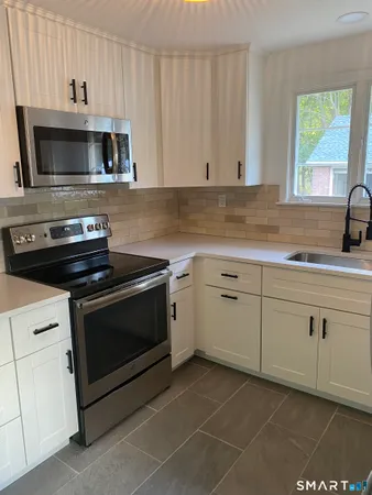 a kitchen with white cabinets stainless steel appliances and sink
