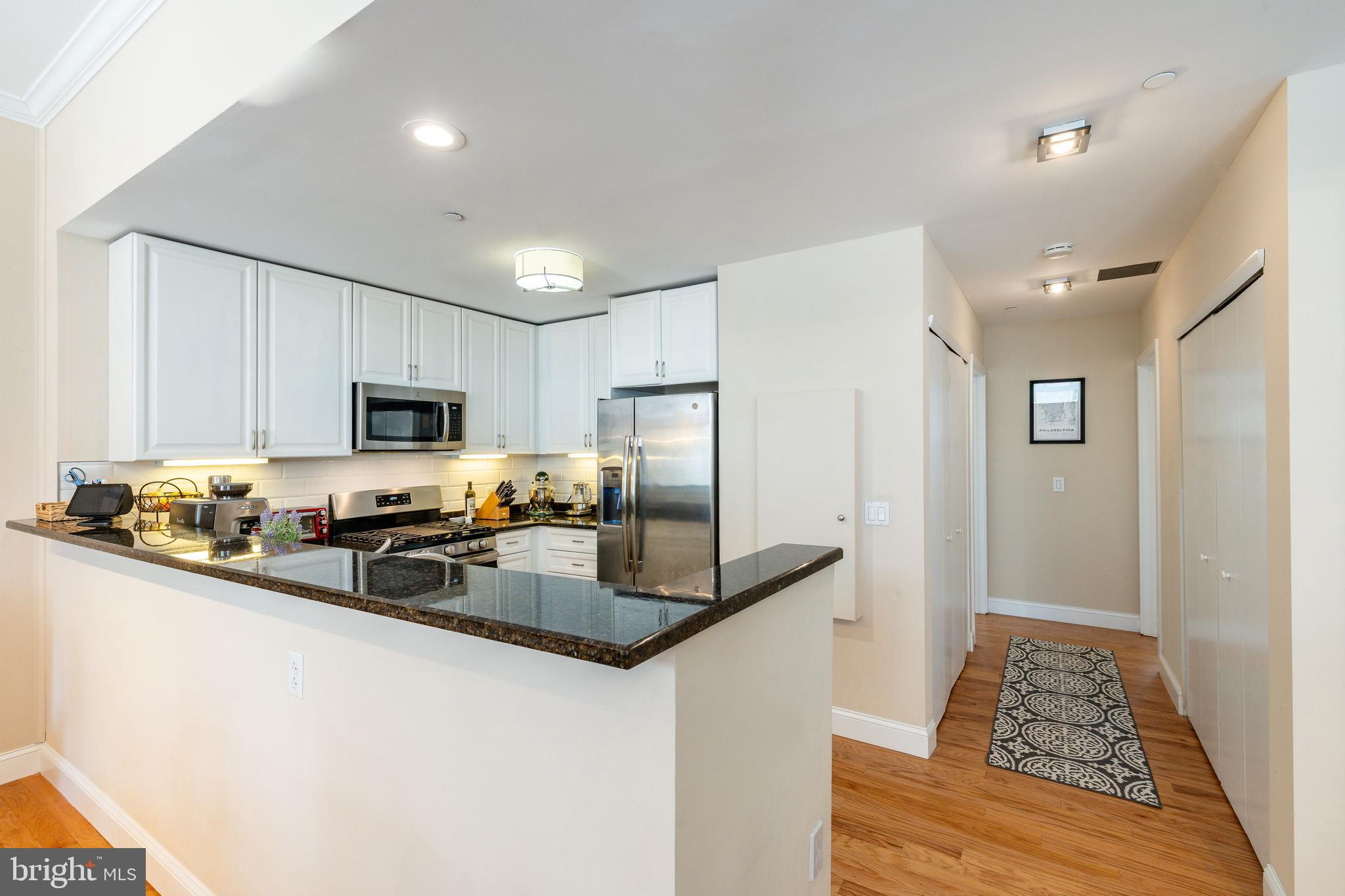 1900 Hamilton Street, Unit C6 Philadelphia, PA 19130 - Photo 11 of 37 a kitchen with stainless steel appliances granite countertop a refrigerator a stove a sink and a microwave