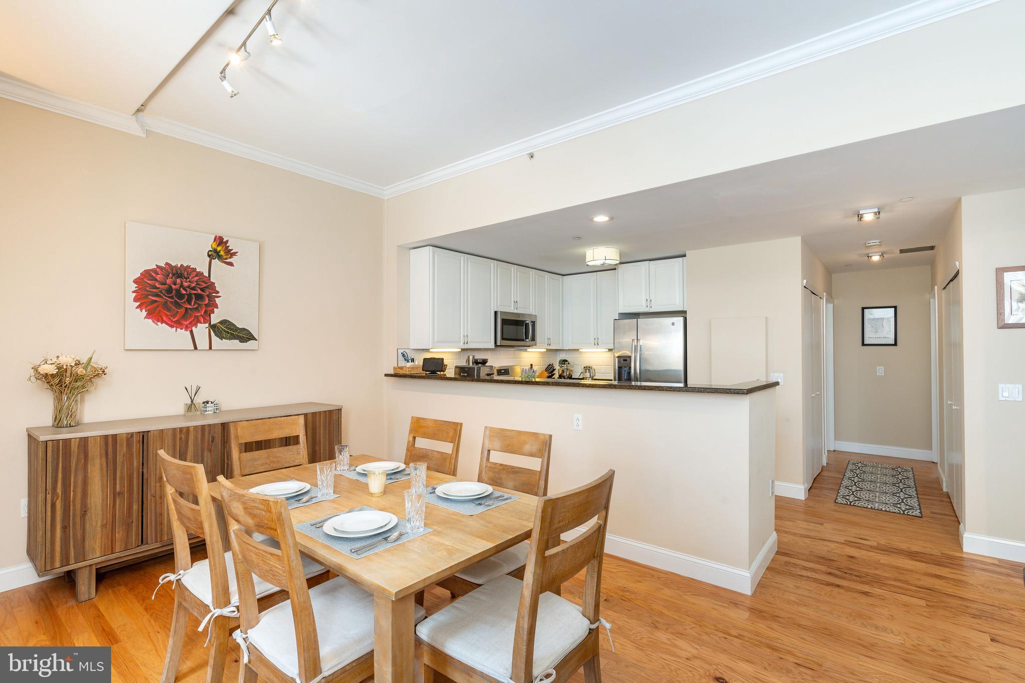 1900 Hamilton Street, Unit C6 Philadelphia, PA 19130 - Photo 9 of 37 a kitchen with stainless steel appliances granite countertop a dining table and chairs with wooden floor