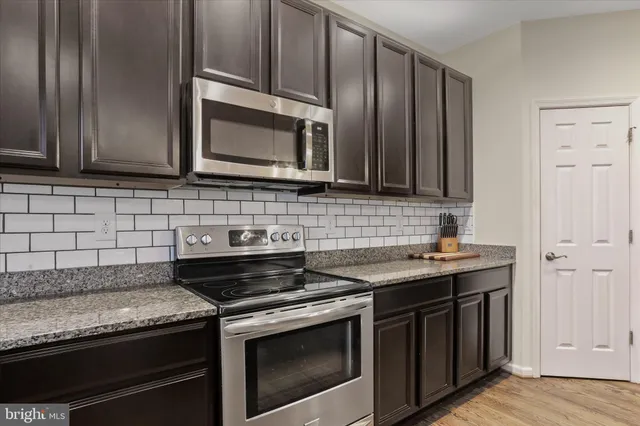 a kitchen with granite countertop a stove and a sink