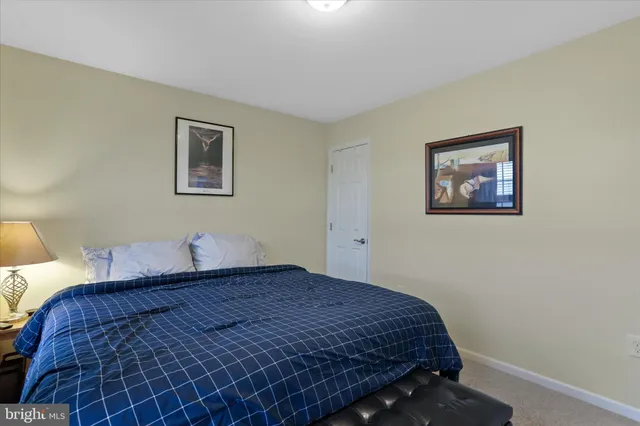 a bedroom with a bed and a painting on the wall