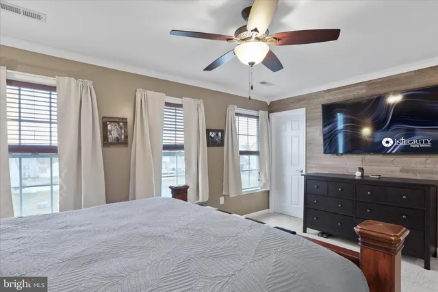 a bedroom with a large bed and a flat tv screen on dresser