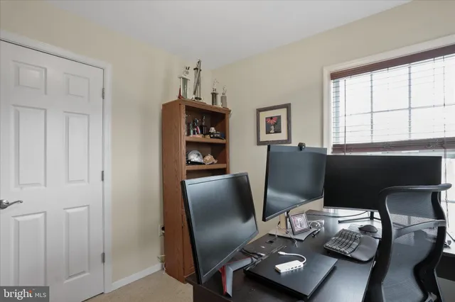 a view of a workspace with furniture and a window