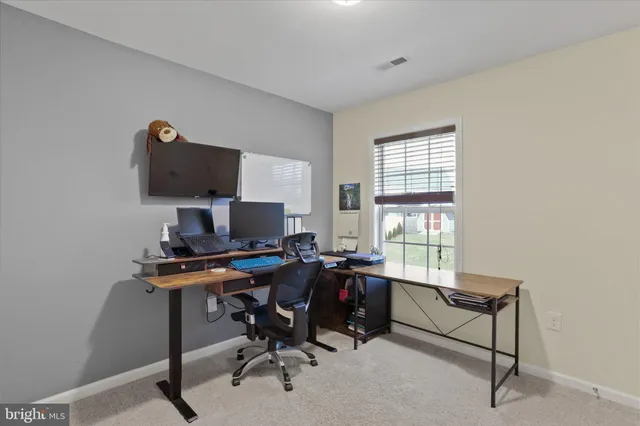 a view of a workspace with furniture and a window