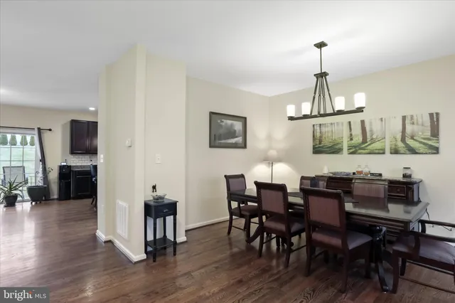 a view of a dining room and livingroom with furniture wooden floor a chandelier