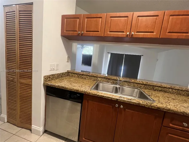 a kitchen with granite countertop stainless steel appliances a sink dishwasher and cabinets