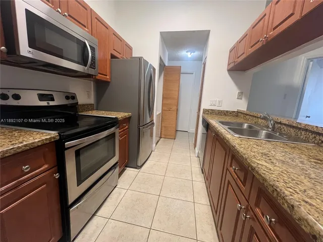 a kitchen with stainless steel appliances granite countertop a stove and a microwave