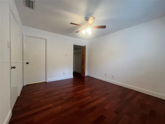 an empty room with a window and a fan