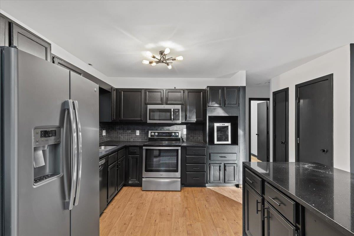 5433 Penrith Drive Durham, NC 27713 - Photo 11 of 47 a kitchen with stainless steel appliances a refrigerator sink and stove