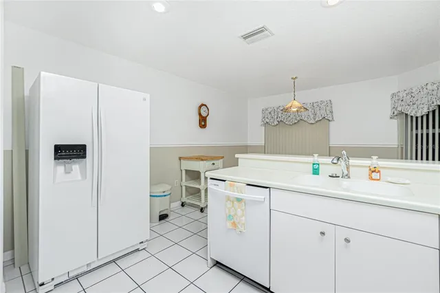 a kitchen with granite countertop white cabinets and white appliances