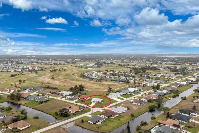 an aerial view of residential houses with outdoor space and ocean view
