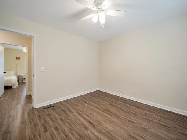 a view of a room with wooden floor and a fan