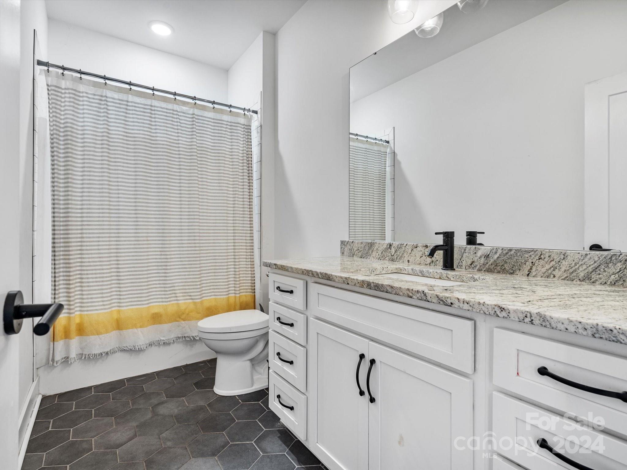 4078 Booney Road Rock Hill, SC 29730 - Photo 21 of 41 a bathroom with a granite countertop sink a toilet a mirror and shower