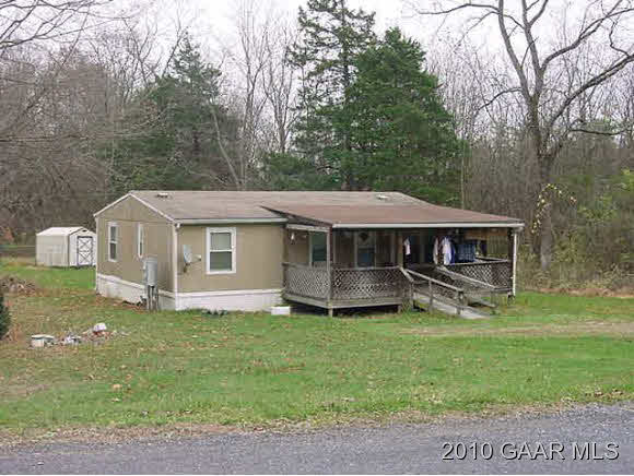 114 Bear Trap Road Mount Solon, VA 22843 - Photo 1 of 2 a house that is sitting in the grass with large trees and wooden fence