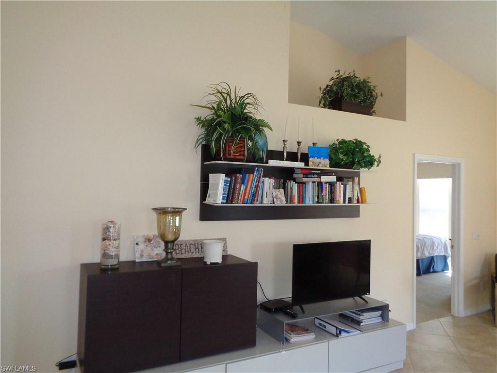 6115 Reserve Circle, Unit 2004 Naples, FL 34119 - Photo 5 of 10 a living room with furniture and a fireplace