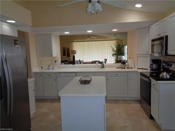 a kitchen with stainless steel appliances granite countertop a sink a stove a refrigerator and a refrigerator