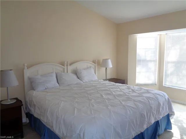 a large bed sitting in a bedroom next to a window